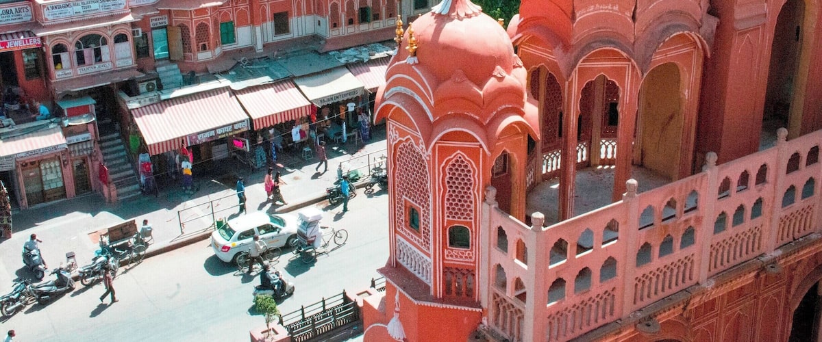 The Hawa Mahal, or "Palace of the Winds" in the foreground, was constructed in the late 18th century by the Maharaja Sawai Pratap Singh so that the ladies of royal household could watch processions on the street below without being seen from the outside.