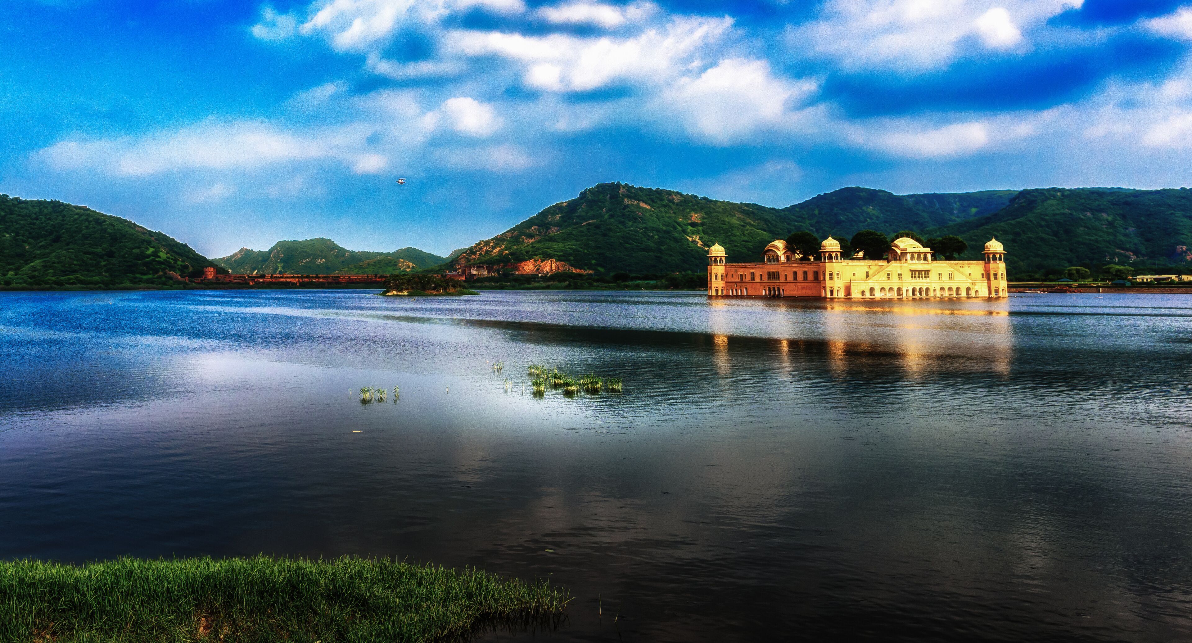 A panoramic view of the Jal Mahal of Jaipur on the blue water under the monsoon clouds, India