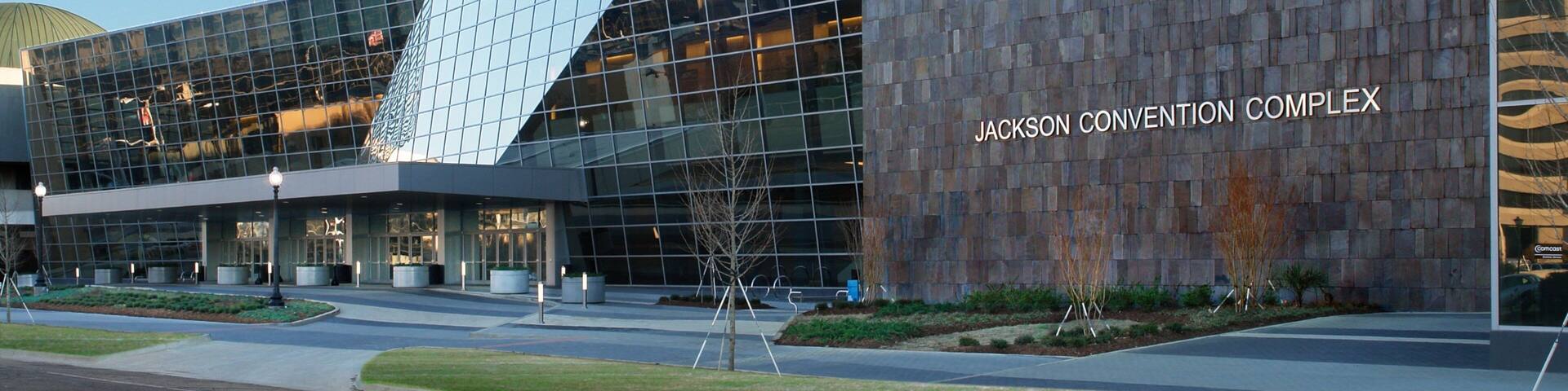 The Jackson Convention Complex with a modern glass facade and a stone-textured wall.