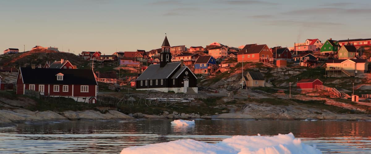 Ilulissat which includes a sunset, a city and a lake or waterhole