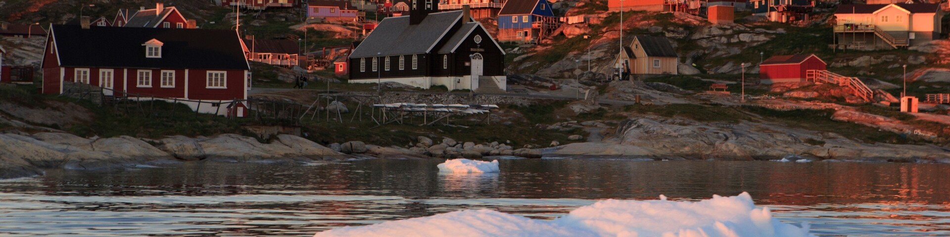 Ilulissat que inclui um pôr do sol, uma cidade e um lago ou charco