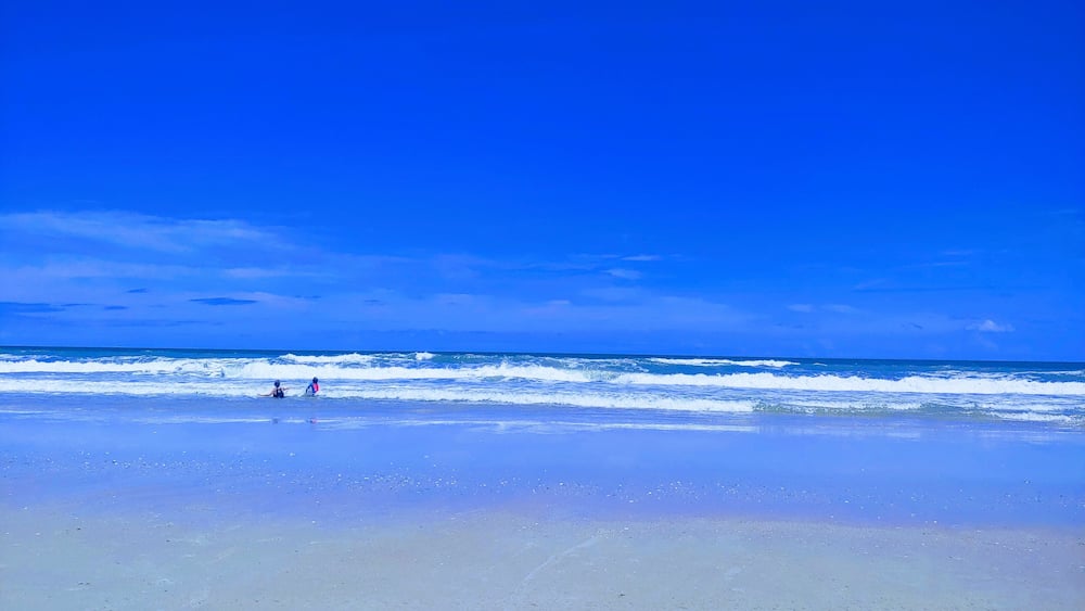 A beach with clear blue sky and ocean waves.
