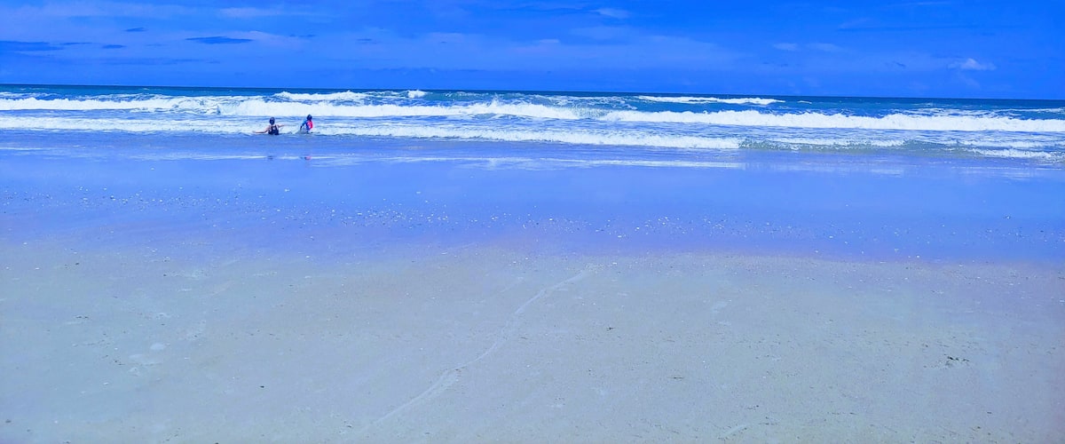 A beach with clear blue sky and ocean waves.