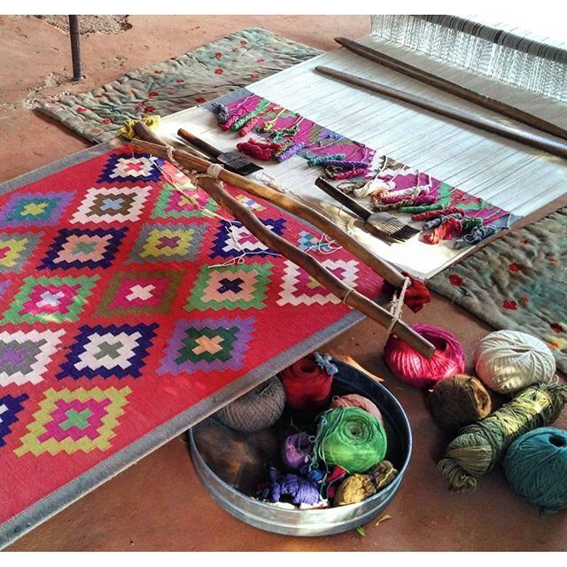 A traditional loom with colorful fabrics and yarns.