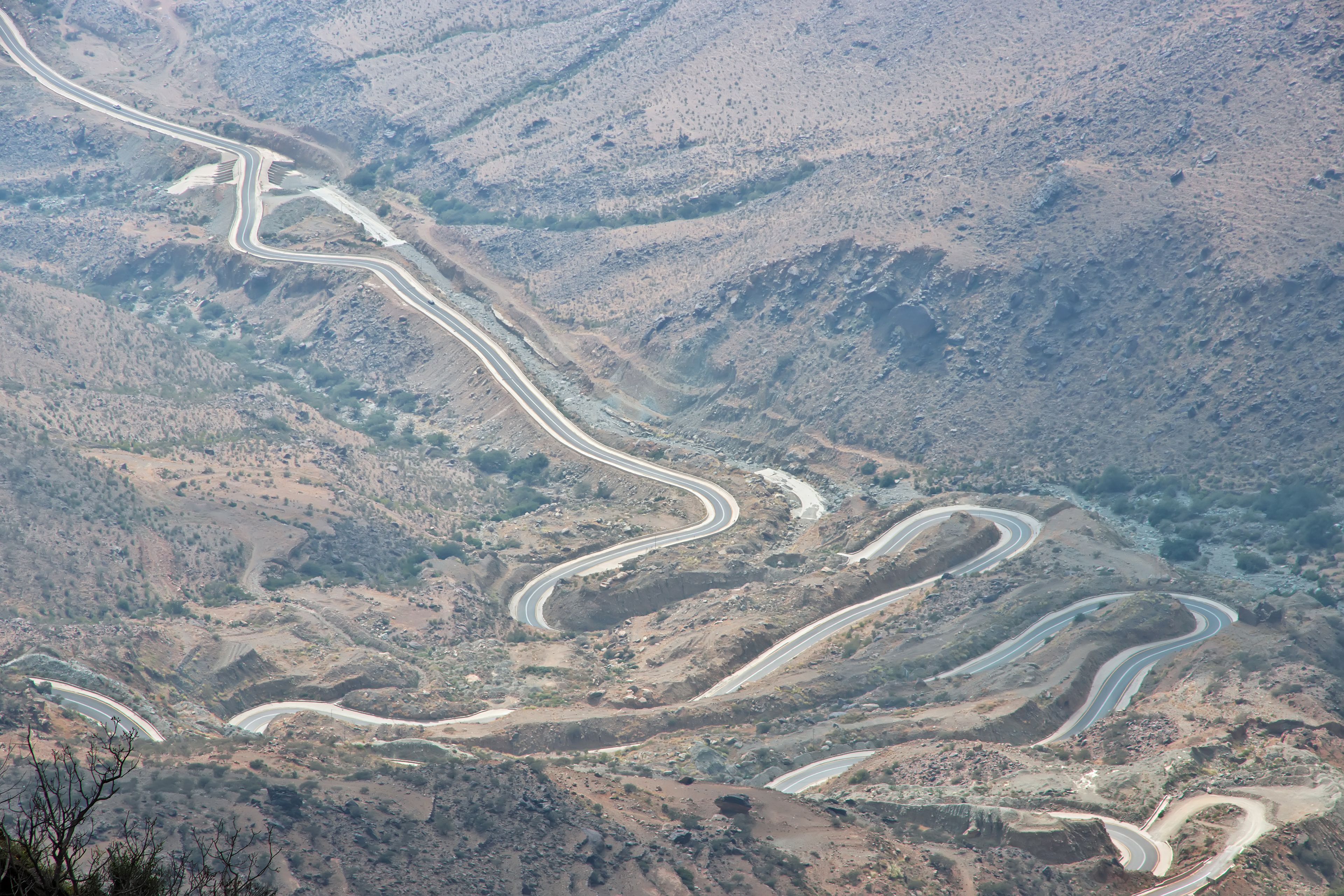 Una carretera de montaña sinuosa con múltiples curvas y un paisaje rocoso.
