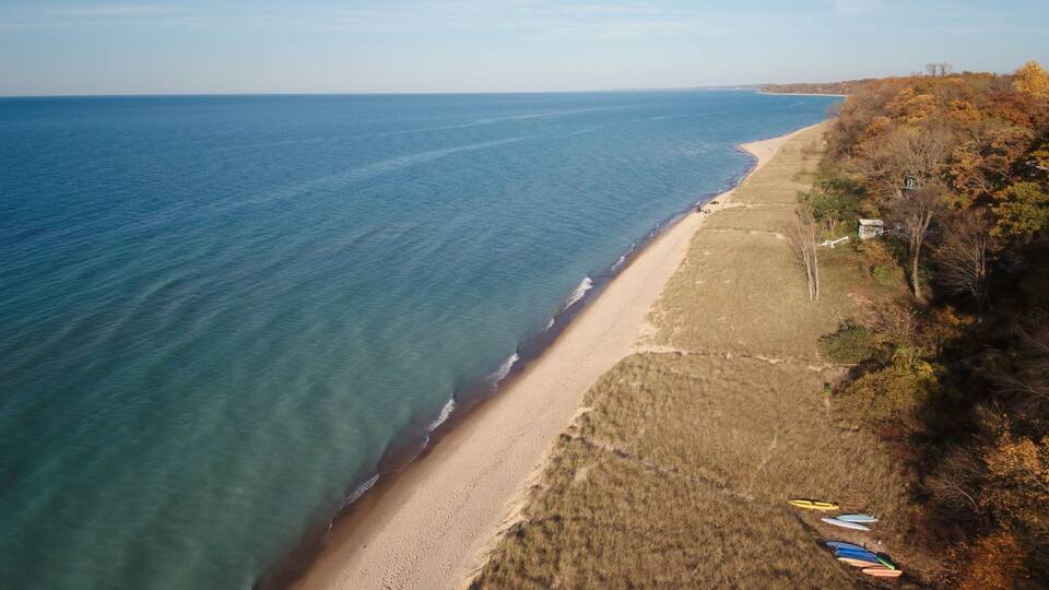 A coastal beach with kayaks and a clear view of the ocean.