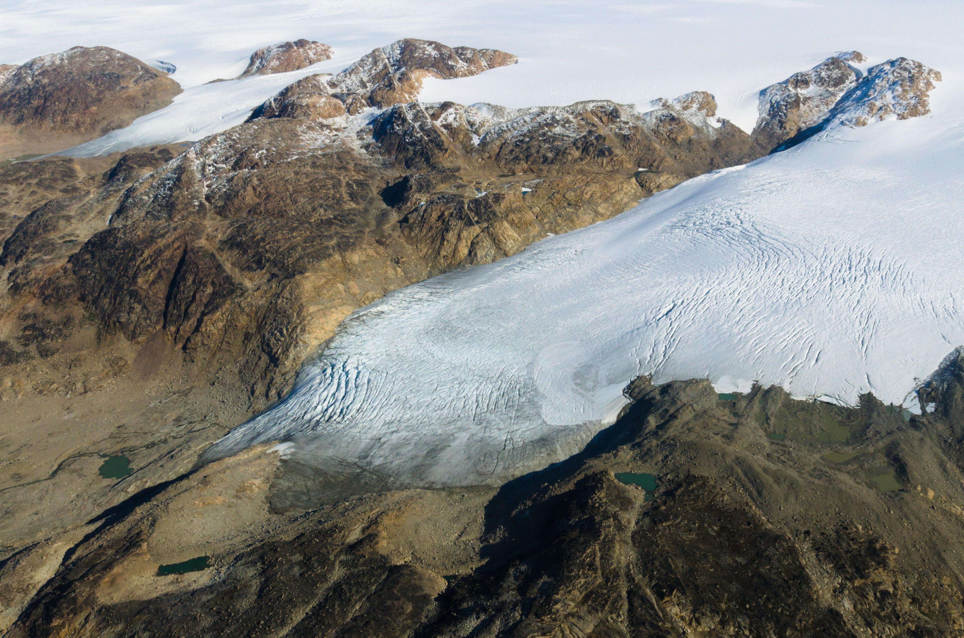 A glacier with rugged mountains in the background.