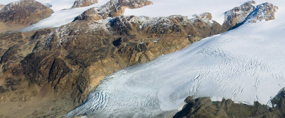 A glacier with rugged mountains in the background.