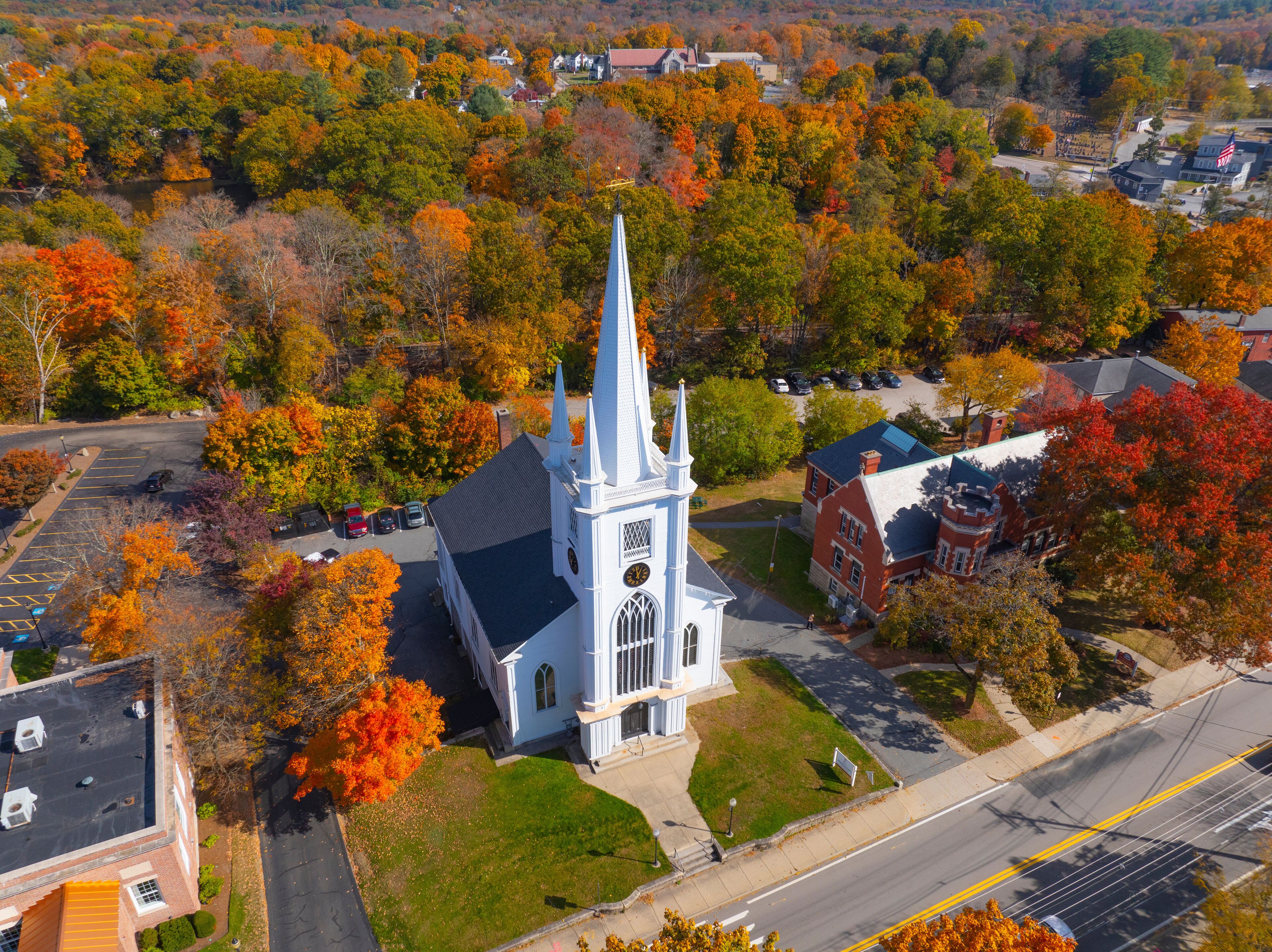 Unitarian Church aerial view in fall with fall foliage at 21 N Main Street in historic town center of Uxbridge, Massachusetts MA, USA. 