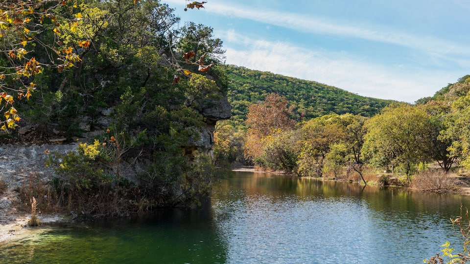 A river surrounded by dense forest and hills.