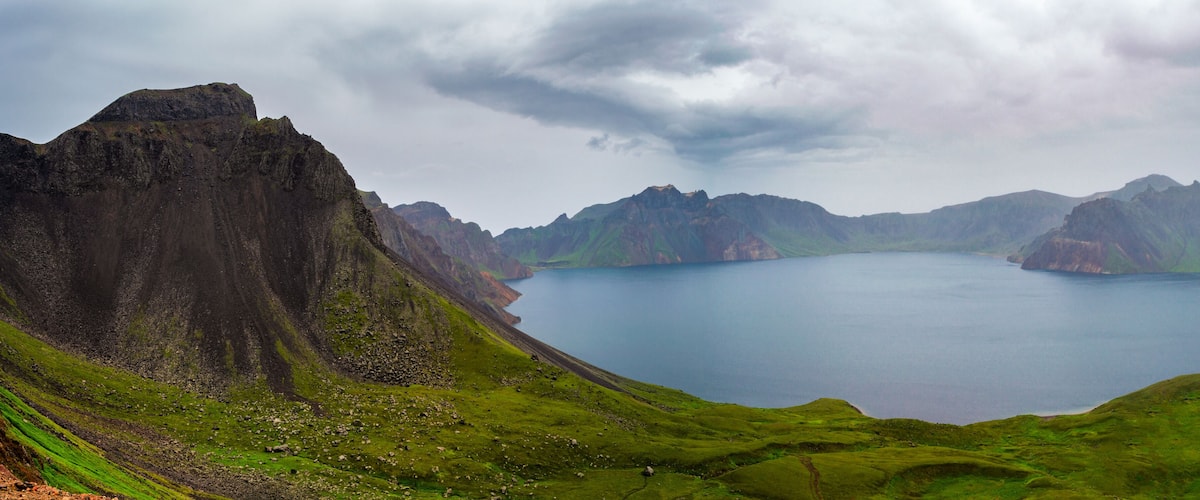 A mountainous landscape with a large lake surrounded by rugged peaks.