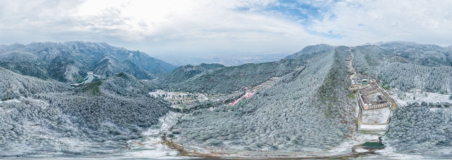 Un paisaje montañoso con una carretera sinuosa y edificios en una colina.