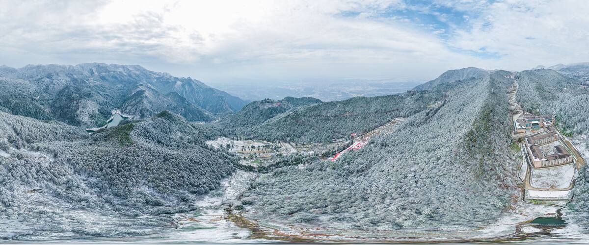 A mountainous landscape with a winding road and buildings on a hill.