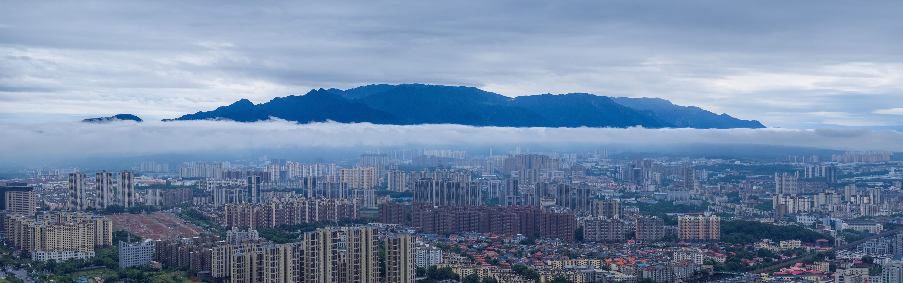 blue mountains on urban clouds and mist panorama