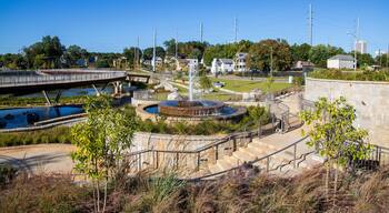 a gorgeous autumn landscape at Rodney Cook Sr. Park in Historic Vine City with water fountains surrounded by lush green trees, grass and plants with a gorgeous blue sky in Atlanta Georgia USA