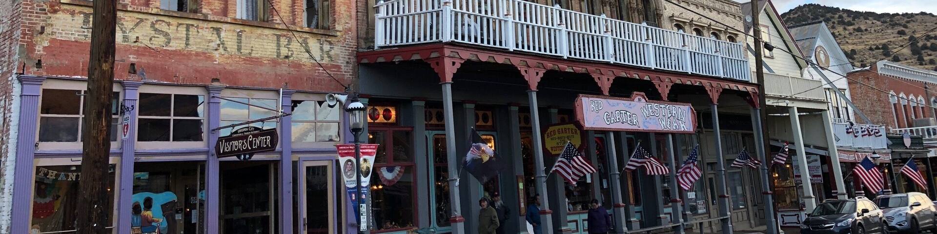 A historic street with vintage buildings, including a Western-themed bar and a vintage car shop.