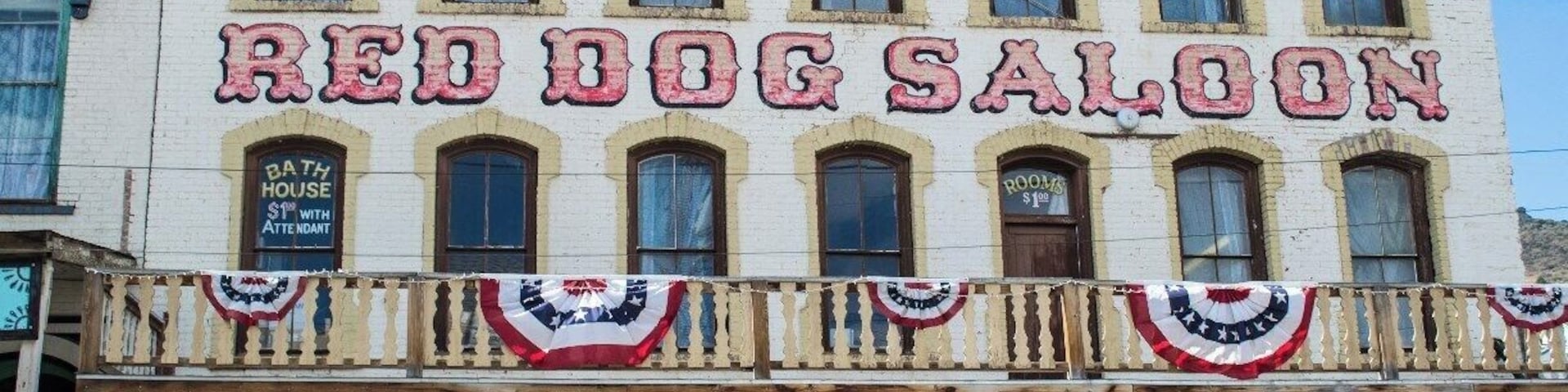 Un edificio con un letrero que dice "Red Dog Saloon" y "Bath House".