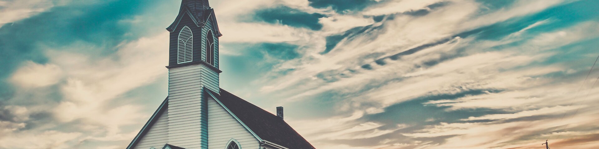 Ellis County, KS, USA - A Lone Wooden Christian Church at Dusk Sunset Skies in the Western Kansas Prairie