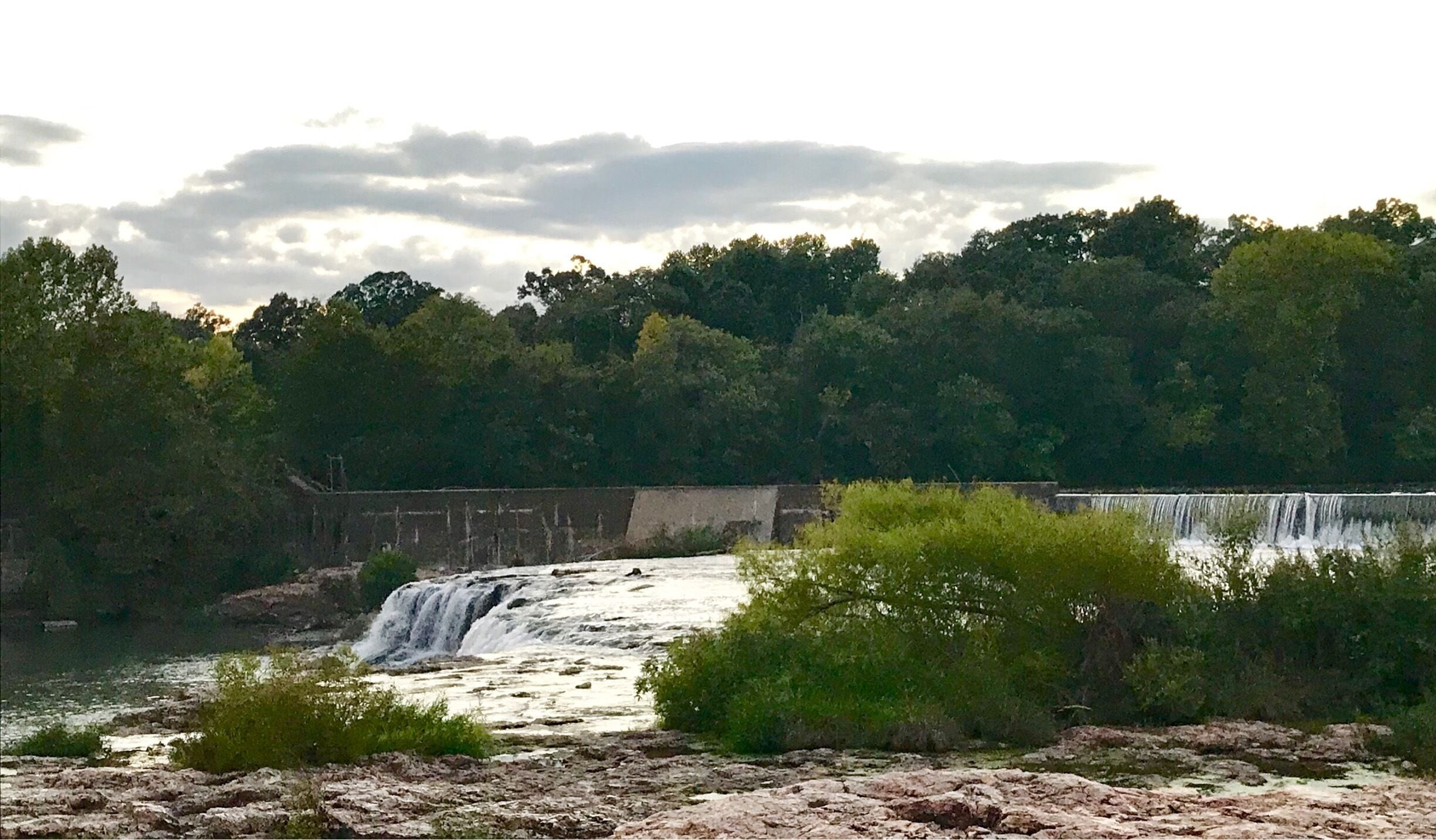 One of Missouri’s least-talked-about wonders is located on Shoal Creek, just south of Joplin. Grand Falls, Missouri’s largest natural, continually flowing waterfall, is like a miniature Niagara Falls. On a breezy day, you’ll feel the mist hit your face. It’s exhilarating to find a natural, beautiful spot such as this on a warm summer day in the Missouri Ozarks.

You can climb down a bit of umber-colored chert, also known as flint, as you head toward this scenic stop. One of the widest waterfalls in the state, Grand Falls is caused by unusually thick layers of chert rock.

Although Missouri does have higher waterfalls, they don’t flow all year like Grand Falls. During high water, the height of the falls increases to roughly 25 feet.

As you walk toward Grand Falls, be sure to take in the beauty of the rock formations. The chert is often pocked with pools of water, making tiny natural swimming pools for frogs or small plants to grow and abide.

To reach the falls from the junction of Interstate 44 and Highway 86, go south one mile, cross Shoal Creek and turn right immediately after crossing the bridge. Follow the drive along the south bank of Shoal Creek for three more miles. Be on the lookout for the falls on your right. The approach from the north side is on private property.