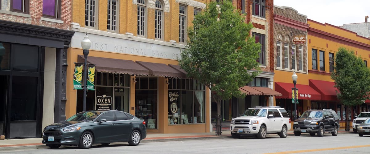 A street with historic buildings, including a bank and a restaurant.