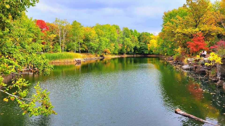 A calm river surrounded by autumn foliage.