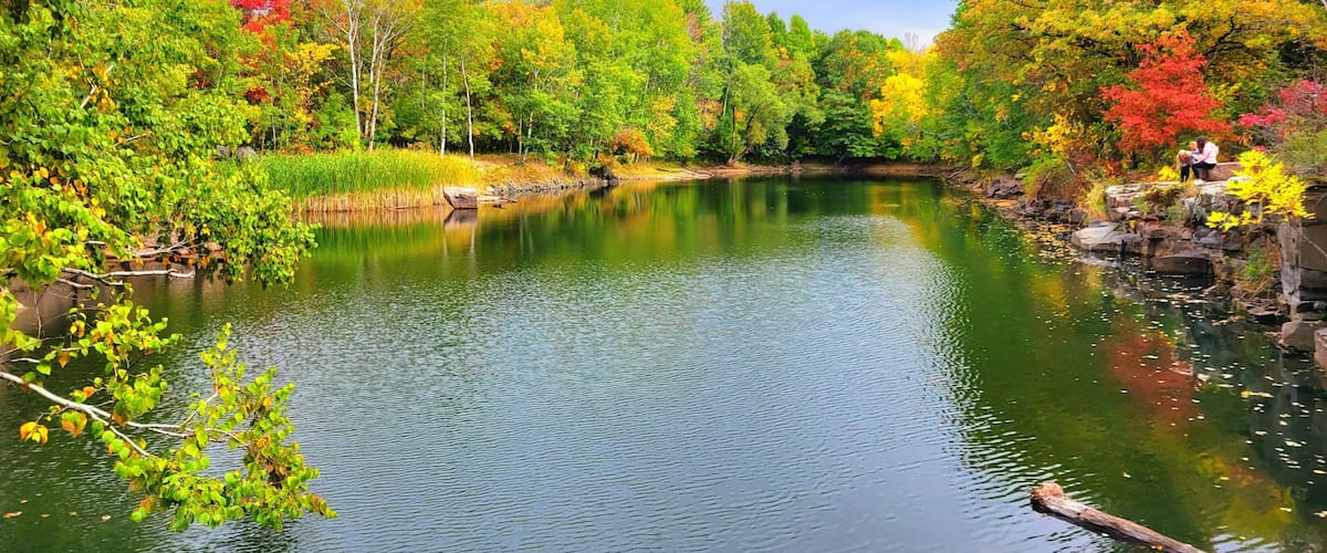A calm river surrounded by autumn foliage.