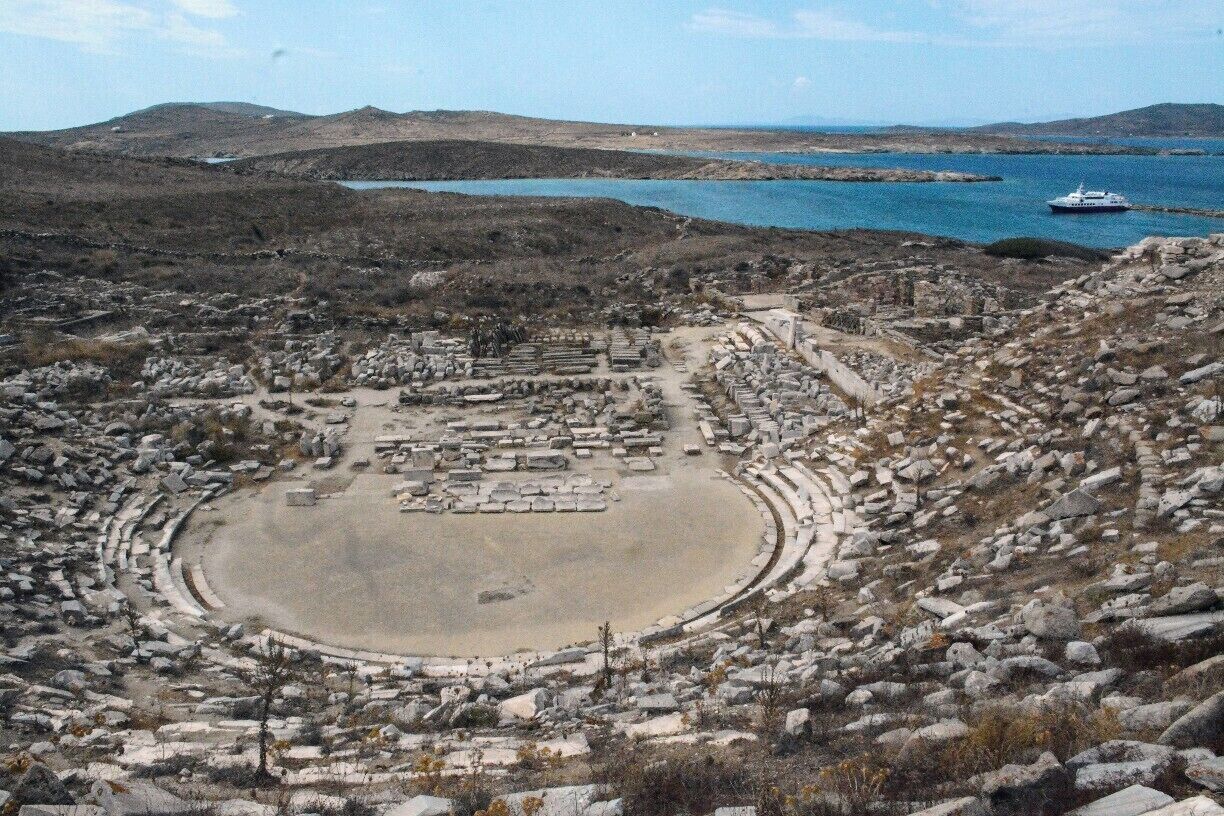 Delos was once the commercial and sacred heart of the Cyclades, with tens of thousands of people. Now it is an unpopulated ruin and a UNESCO World Heritage Site. It's a quick ferry ride from Mykonos. Here is its theatre from its summit. http://timeanddestination.com/exploring-ruins-delos-greece/