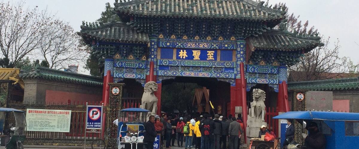 A traditional Chinese gate with intricate designs and a sign above it.