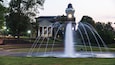 A fountain in front of a building with a clock tower.