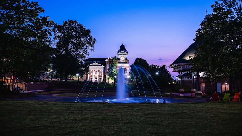 An illuminated view of City Hall in city of Duluth in Georgia shot during sunset with fountain in foreground