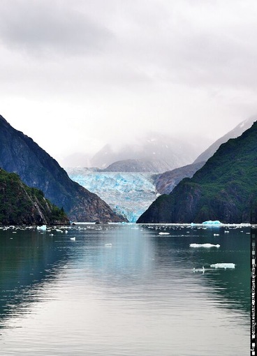 Un glaciar con icebergs en un fiordo rodeado de montañas.