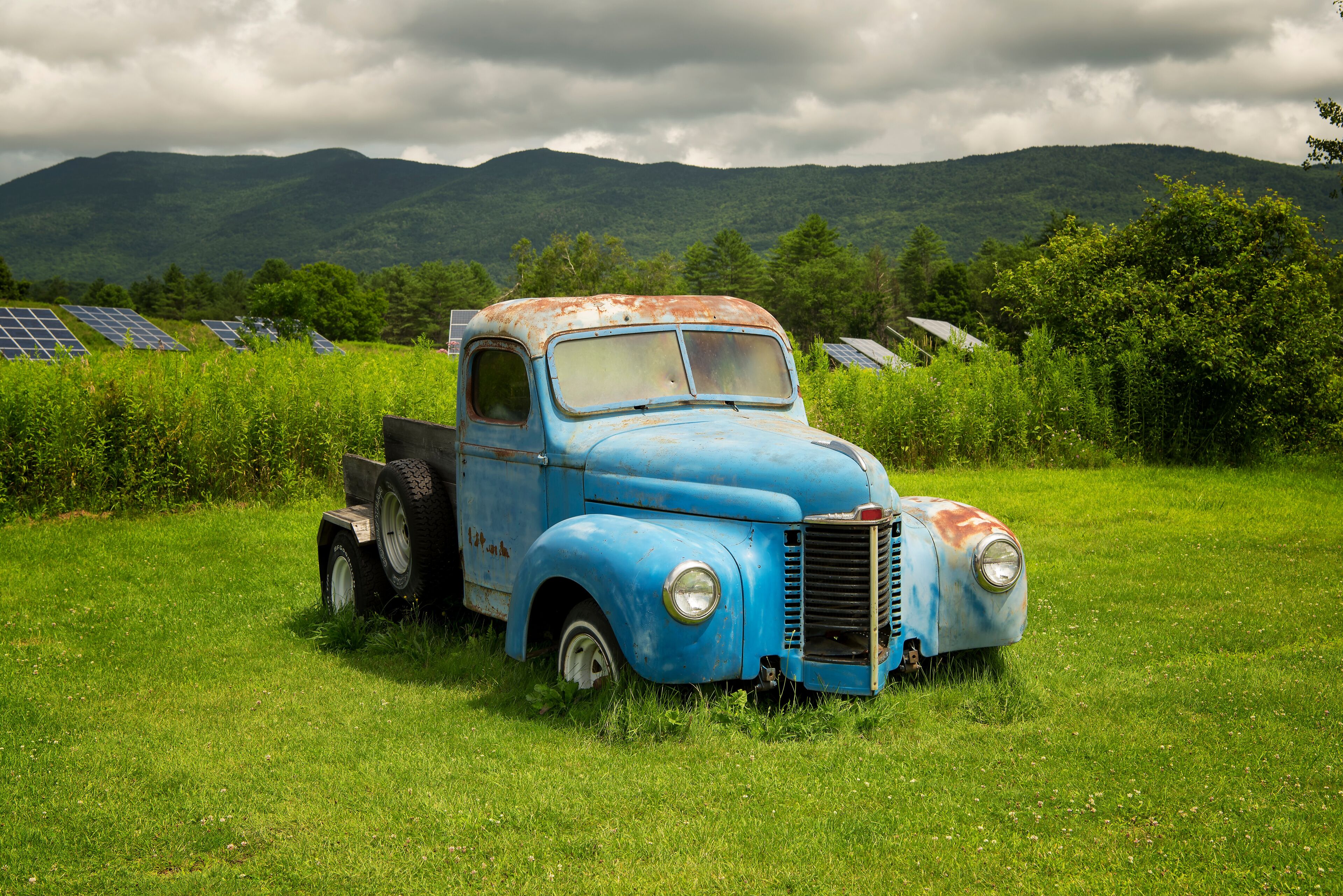 Antique and weathered blue pick up truck in vermont on a sunny day