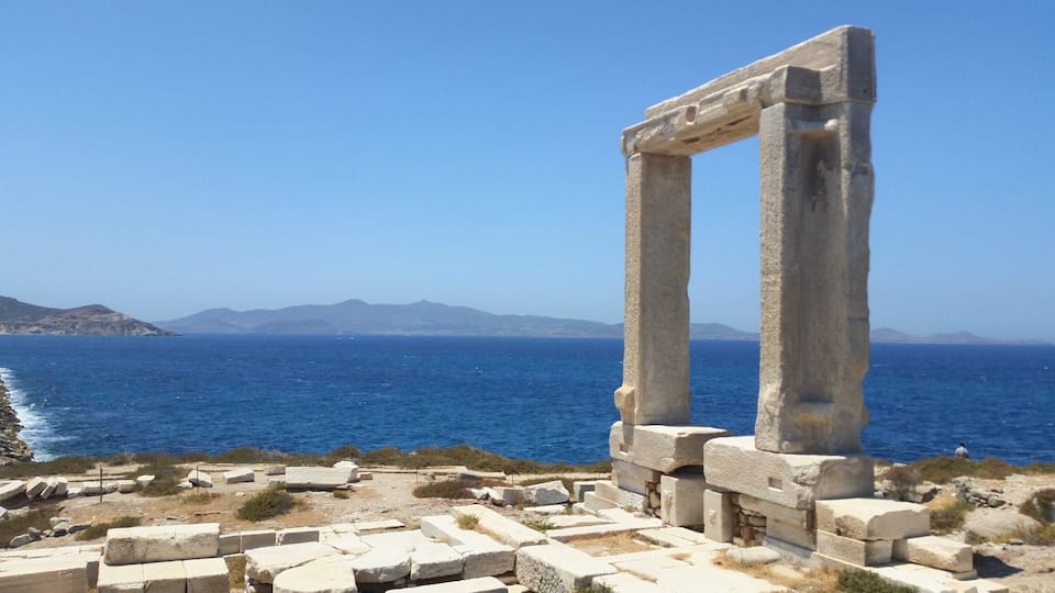 De vieilles ruines de pierre au bord de la mer, offrant une vue dégagée sur l’océan et les collines lointaines.
