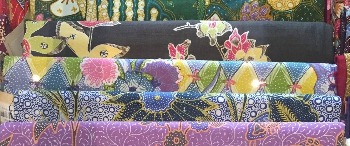 A variety of colorful fabrics with floral and geometric patterns.