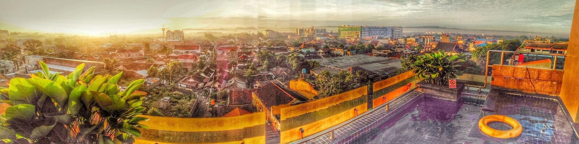 Paisagem urbana com um edifício grande, uma piscina e áreas residenciais ao redor.