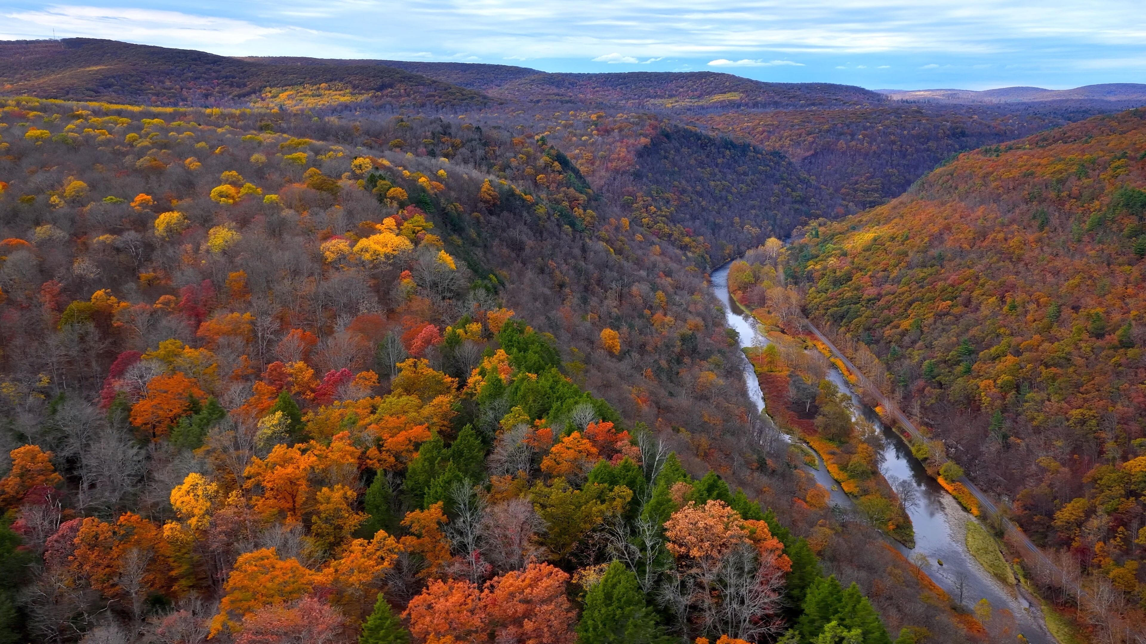 Pennsylvania Grand Canyon Mountains in Autumn Fall Colors, orange and reds with gentle flowing Pine creek in valley below with hiking, biking trail for exercise and relaxing in the nature outdoors