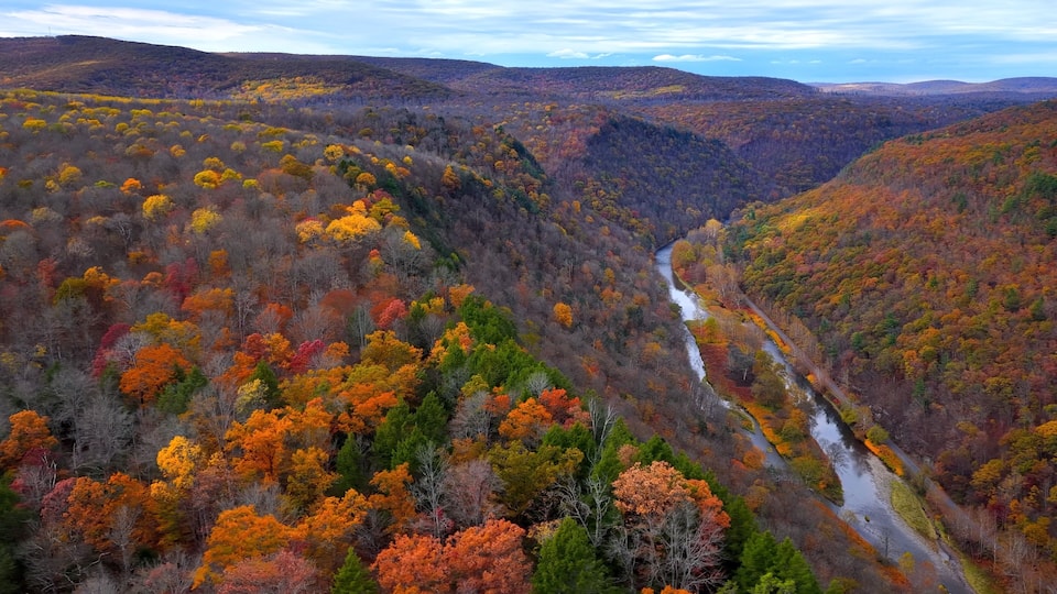 A river winding through a forested valley with autumn foliage.