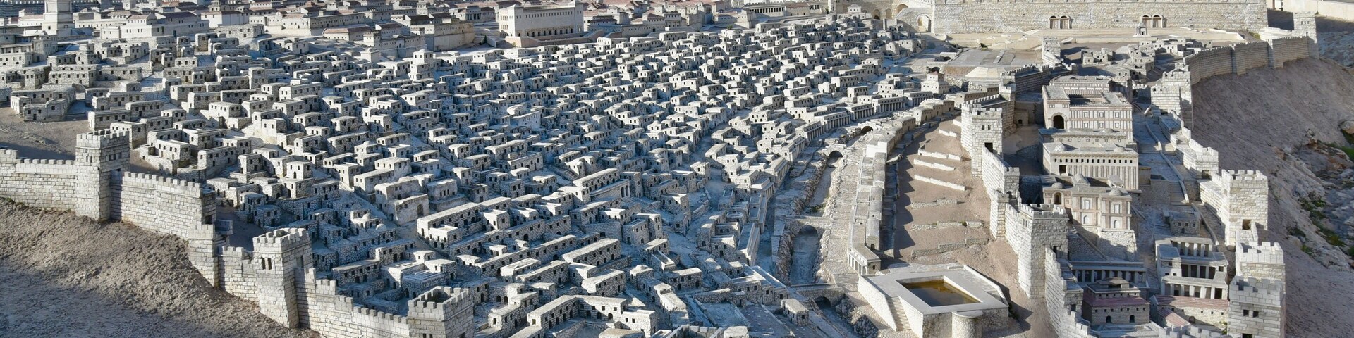 Una gran ciudad amurallada de estilo antiguo, con un espacio abierto central rodeado de edificios densos y de varios niveles.