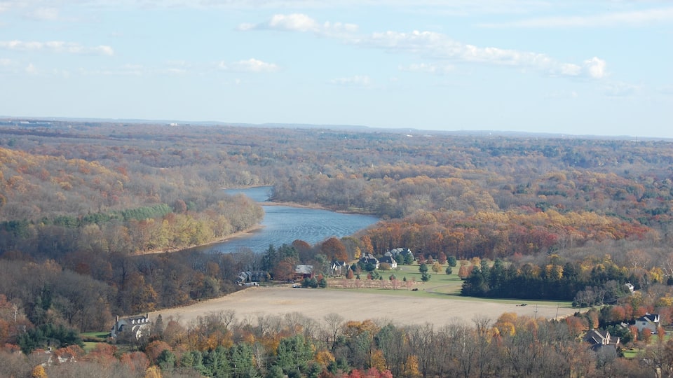 A river winding through a valley with autumn-colored trees and scattered houses.