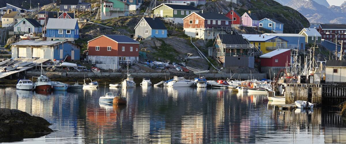 A coastal village with colorful houses and boats docked in the harbor.