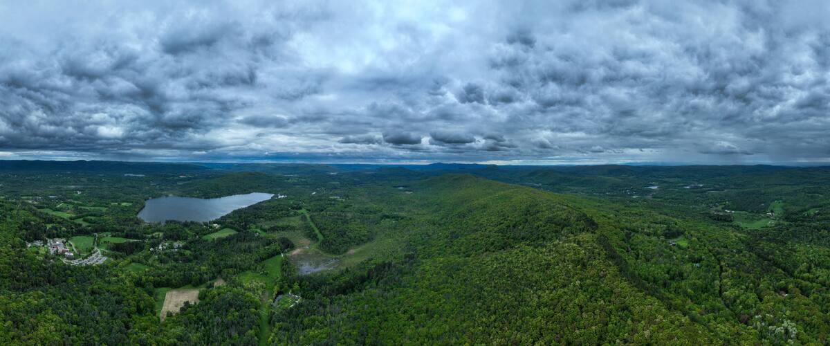 A mountainous landscape with a lake and dense forests.