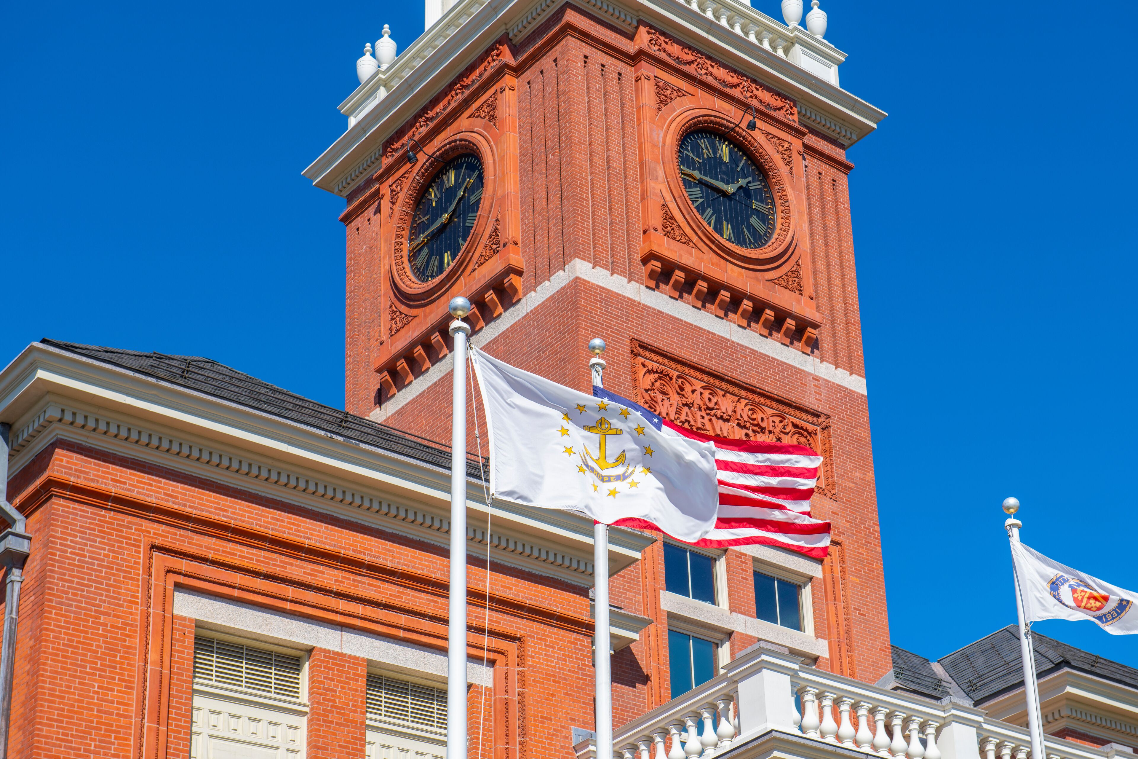 Flag of Rhode Island State in front of Warwick City Hall at 3275 Post Road in village of Apponaug, city of Warwick, Rhode Island RI, USA. 
