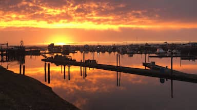 Um pôr do sol sobre um cais com barcos e docas.