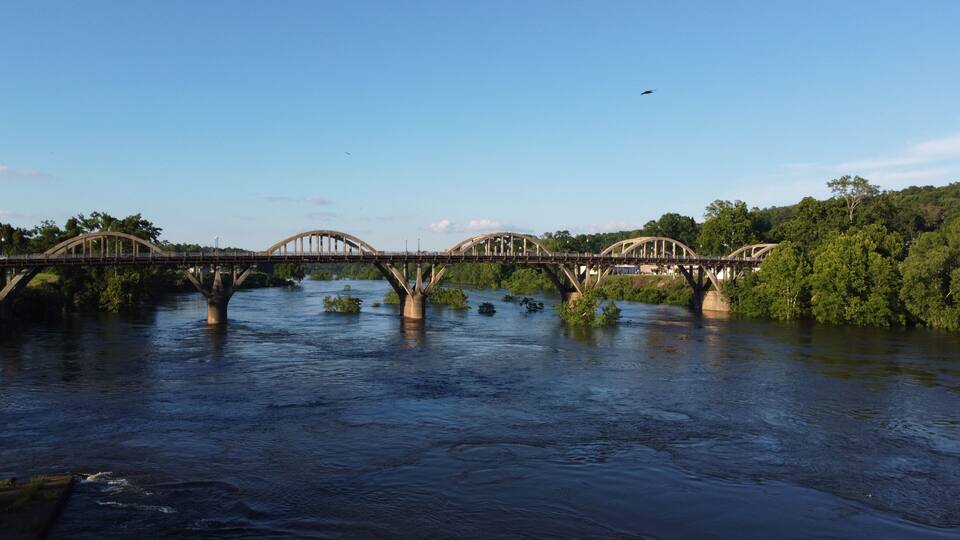 A bridge over a river with trees on both sides.