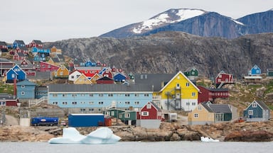 Upernavik showing rocky coastline, mountains and a small town or village
