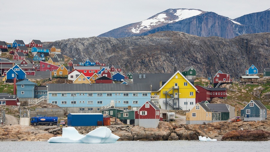 Upernavik featuring mountains, rocky coastline and a small town or village