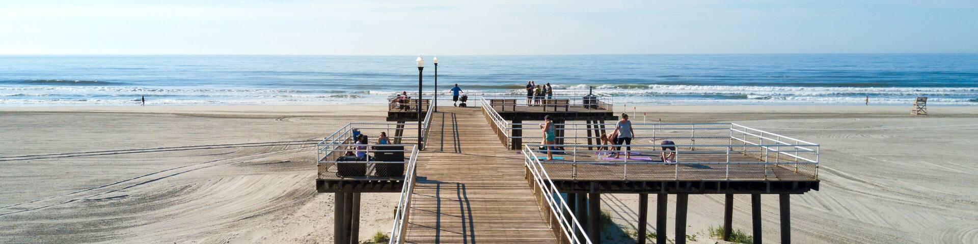 Wildwood Crest beach and wooden dock from above with the ocean view and tourists relaxing, NJ, USA