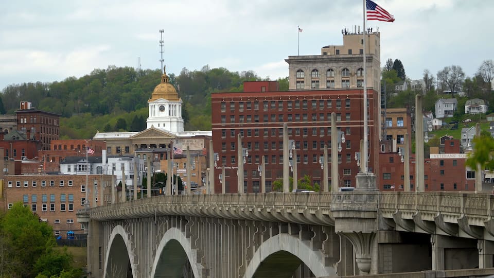 A bridge with arches, a clock tower, and a building with a golden dome.