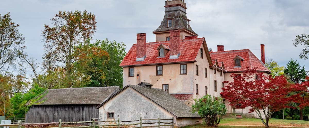 A large, historic building with a red roof and a prominent tower.