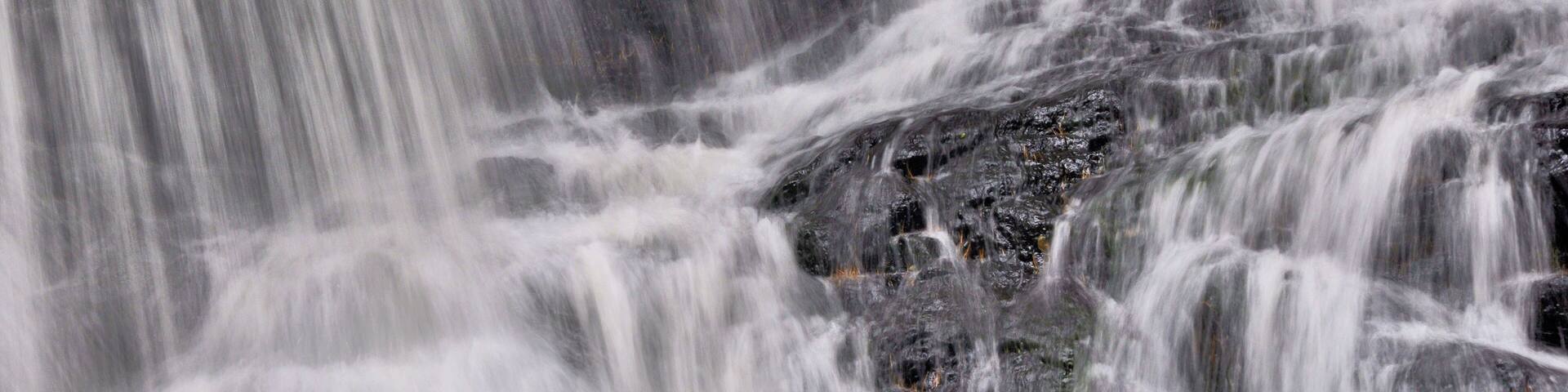 Closeup of white curtains of water plunging down scenic Garwin Falls in Wilton, New Hampshire.